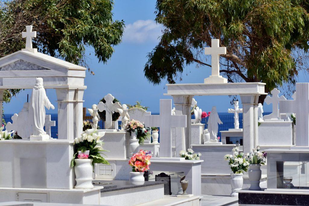 a bunch of white graves with flowers on them